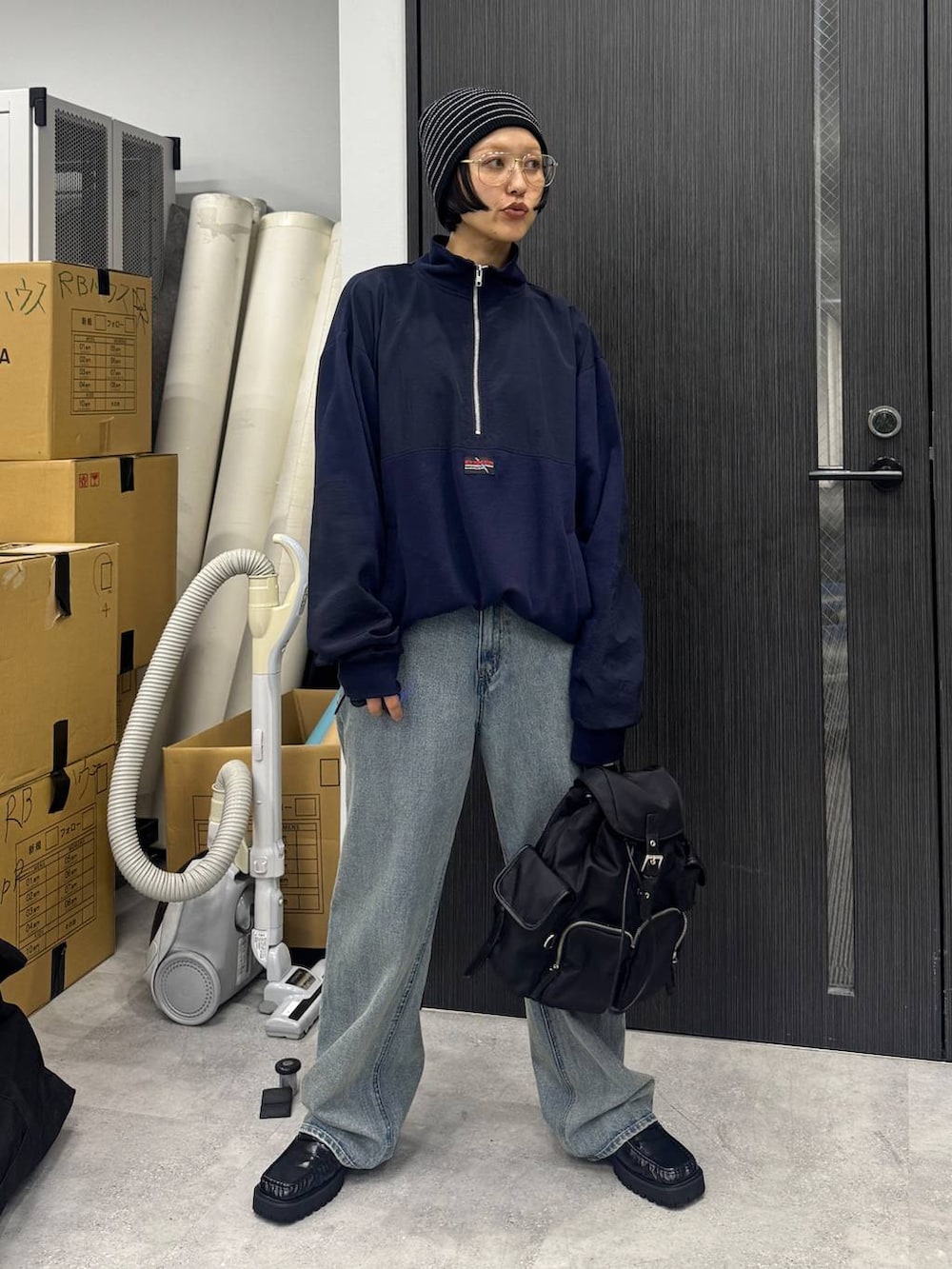 ブラック系のローファー、ブルー系のデニムパンツ、ブラック系のバックパック/リュックを着用したレディースの夏コーディネートの3枚目の写真