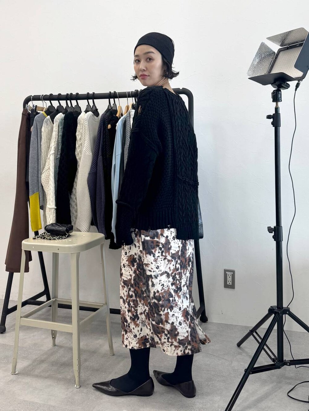 ベージュ系のスカート、ブラック系のショルダーバッグ、ブラック系のニット/セーターを着用したレディースの秋コーディネートの4枚目の写真