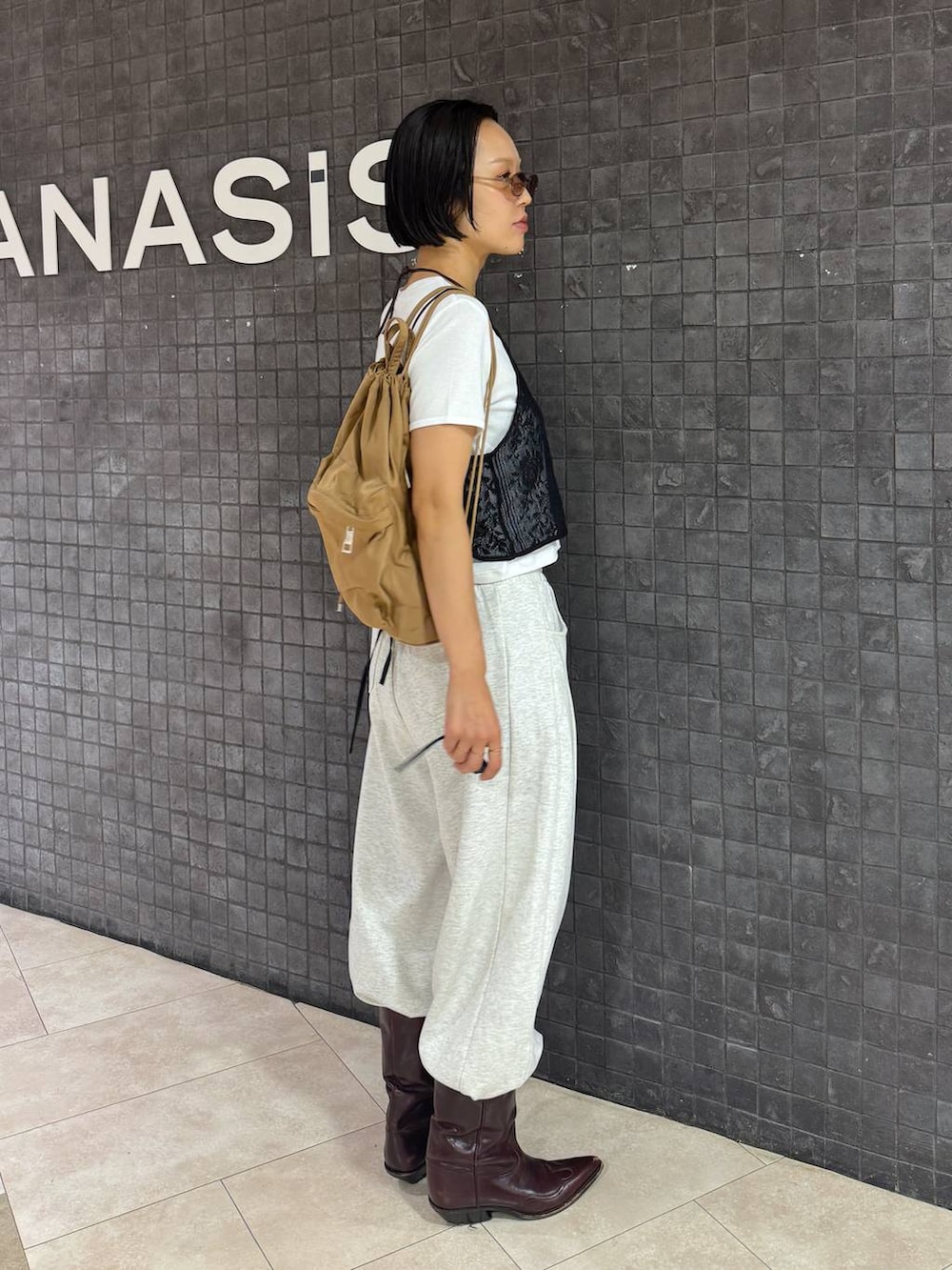 ホワイト系のTシャツ/カットソー、ベージュ系のスウェットパンツ、ブラウン系のサングラスを着用したレディースの夏コーディネートの2枚目の写真
