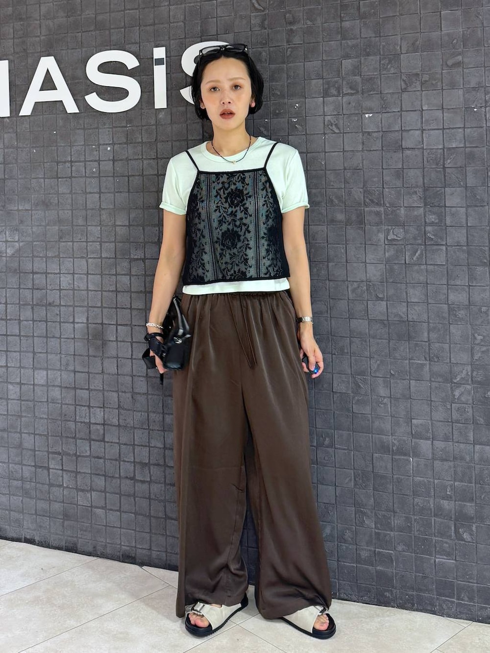 グリーン系のTシャツ/カットソー、ホワイト系のサンダル、ブラウン系のその他パンツを着用したレディースの夏コーディネートの2枚目の写真