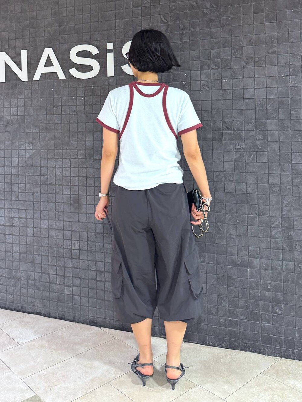 ブラック系のパンプスを着用したレディースの夏コーディネートの2枚目の写真