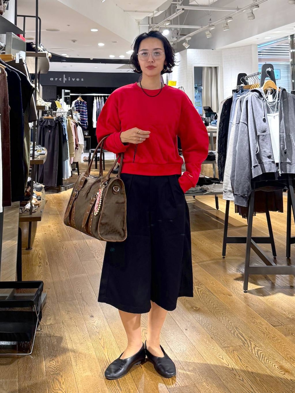 グリーン系のトートバッグ、ブラック系のその他パンツ、レッド系のスウェットを着用したレディースの秋コーディネートの5枚目の写真