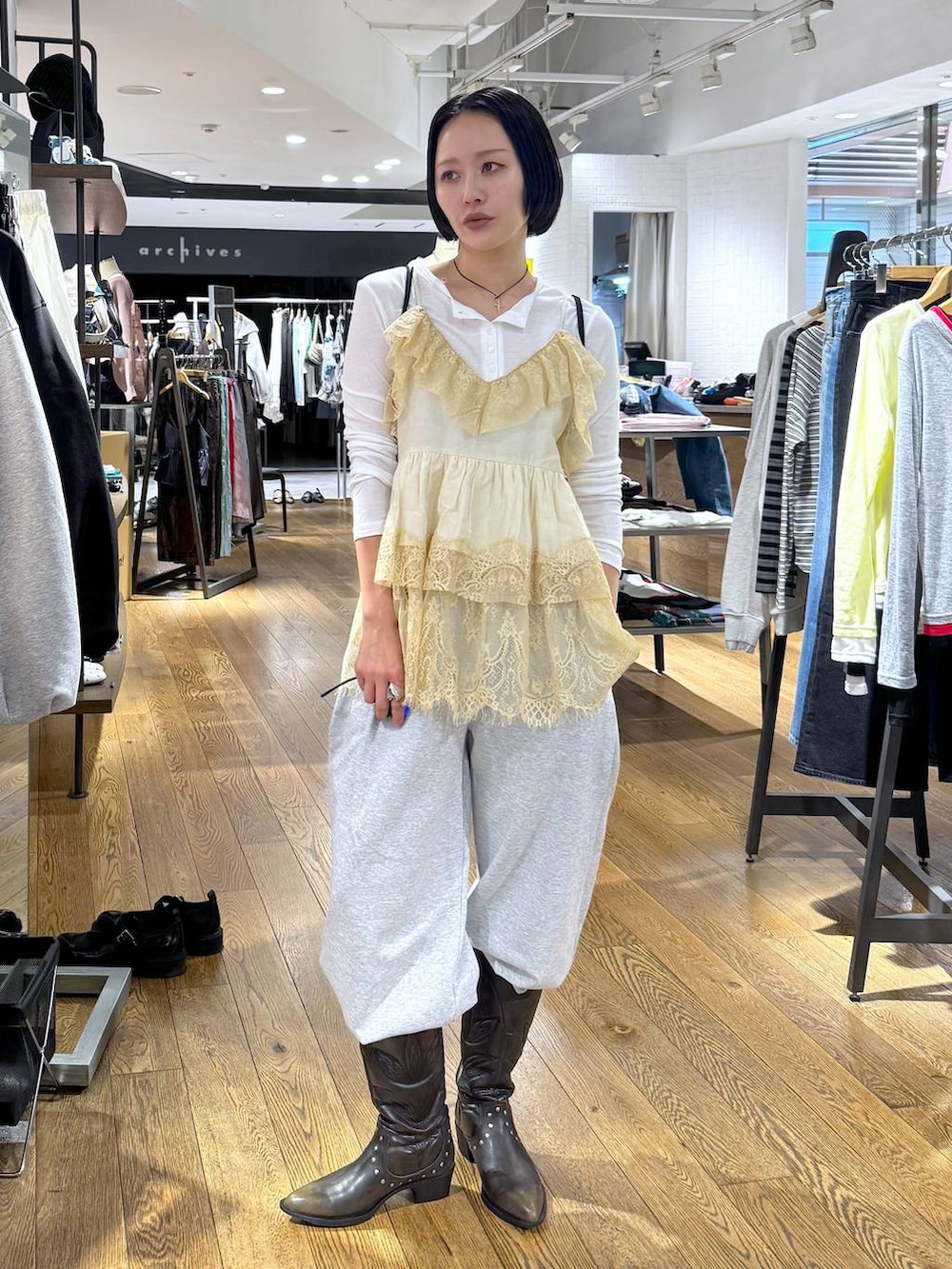 ホワイト系のTシャツ/カットソー、ブラック系のブーツ、グレー系のスウェットパンツを着用したレディースの春コーディネートの2枚目の写真