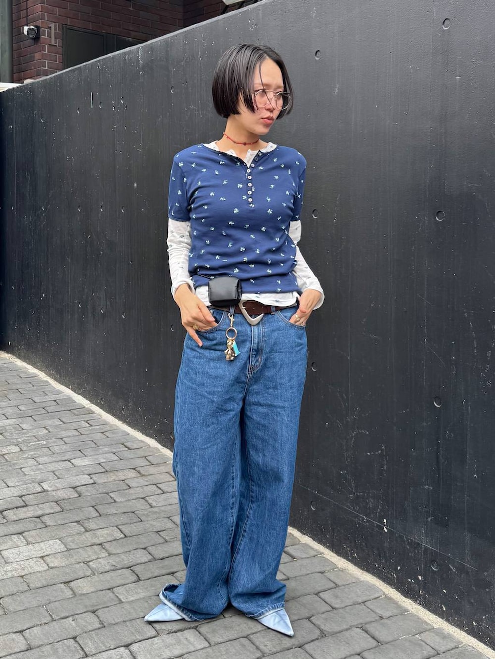 ブラック系のバックパック/リュック、ブルー系のTシャツ/カットソー、ブラウン系のベルトを着用したレディースの春コーディネートの3枚目の写真