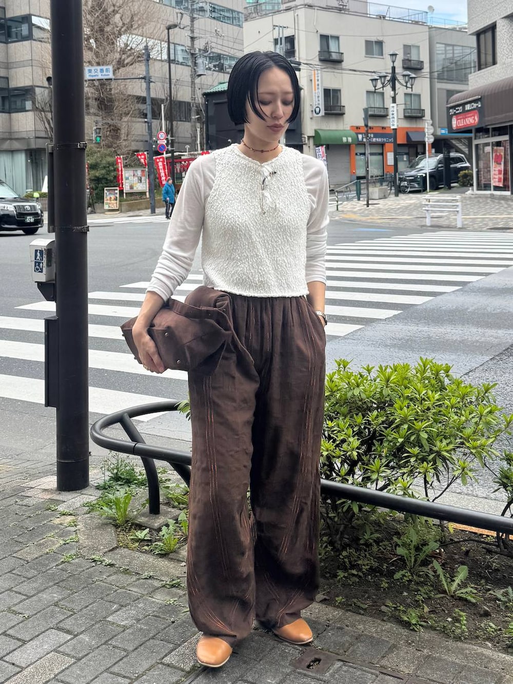 ブラウン系のショルダーバッグを着用したレディースの春コーディネートの2枚目の写真