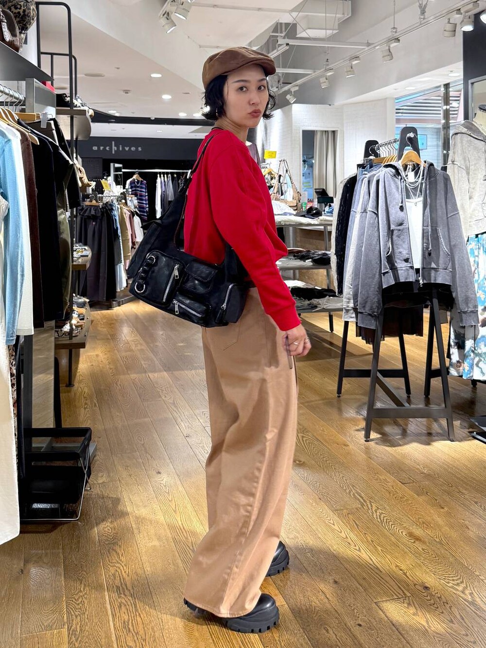 ベージュ系のデニムパンツ、ブラック系のショルダーバッグ、ブラック系のブーツを着用したレディースの秋コーディネートの5枚目の写真