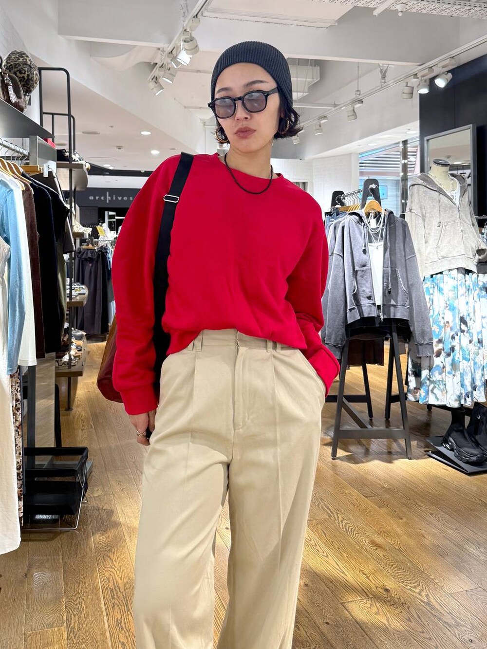 ブラウン系のショルダーバッグ、ブラック系のブーツ、ベージュ系のチノパンツを着用したレディースの秋コーディネートの2枚目の写真