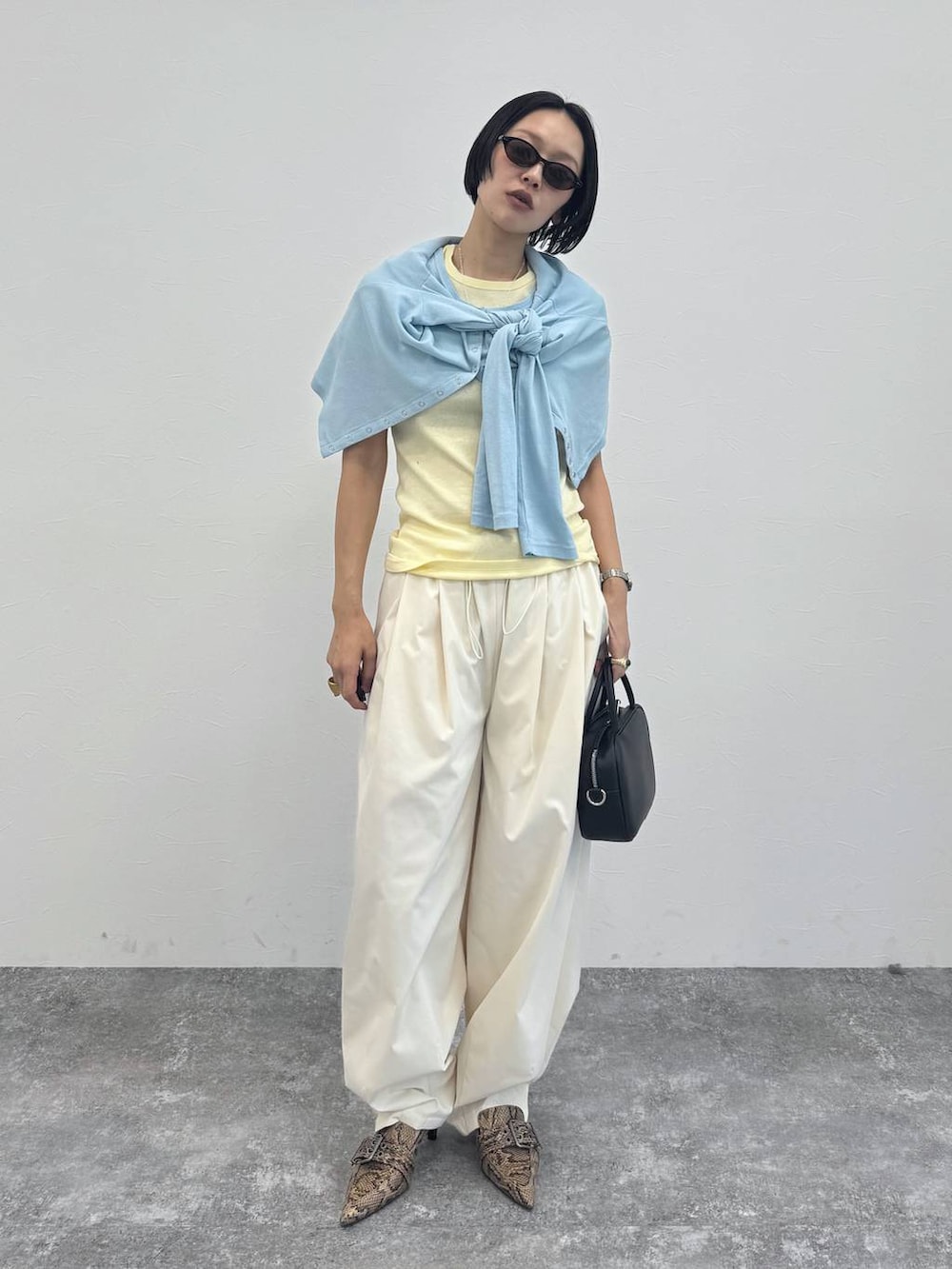 ブラック系のショルダーバッグ、ベージュ系のパンプス、ホワイト系のその他パンツを着用したレディースの冬コーディネートの5枚目の写真