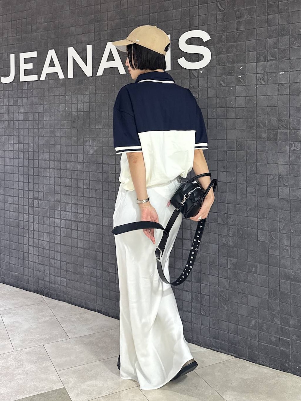 ブラック系のボストンバッグ、ブラック系のスカート、ブラック系のローファーを着用したレディースの春コーディネートの4枚目の写真