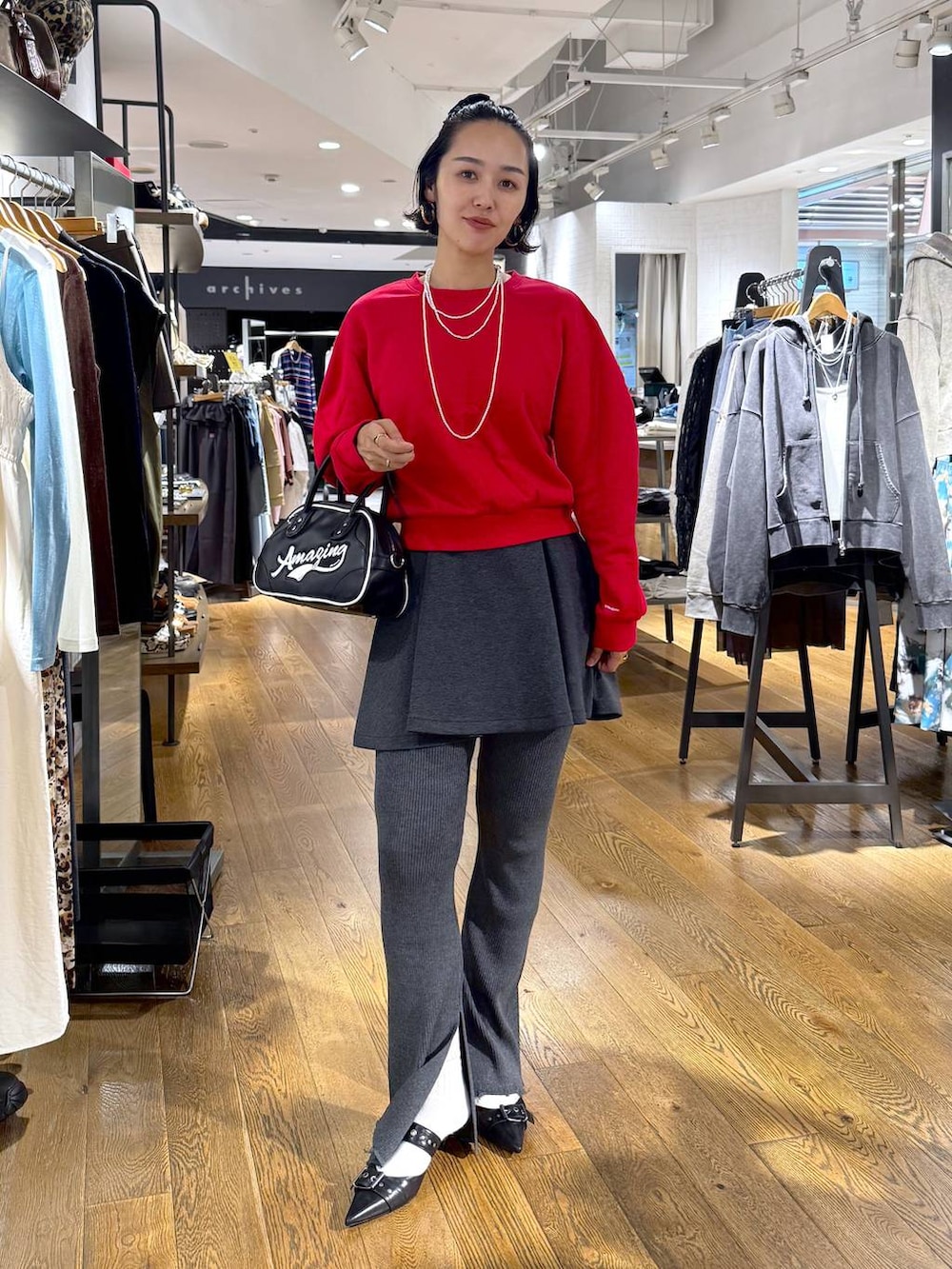 ブラック系のパンプス、ホワイト系のショルダーバッグ、グレー系のその他パンツを着用したレディースの秋コーディネートの5枚目の写真