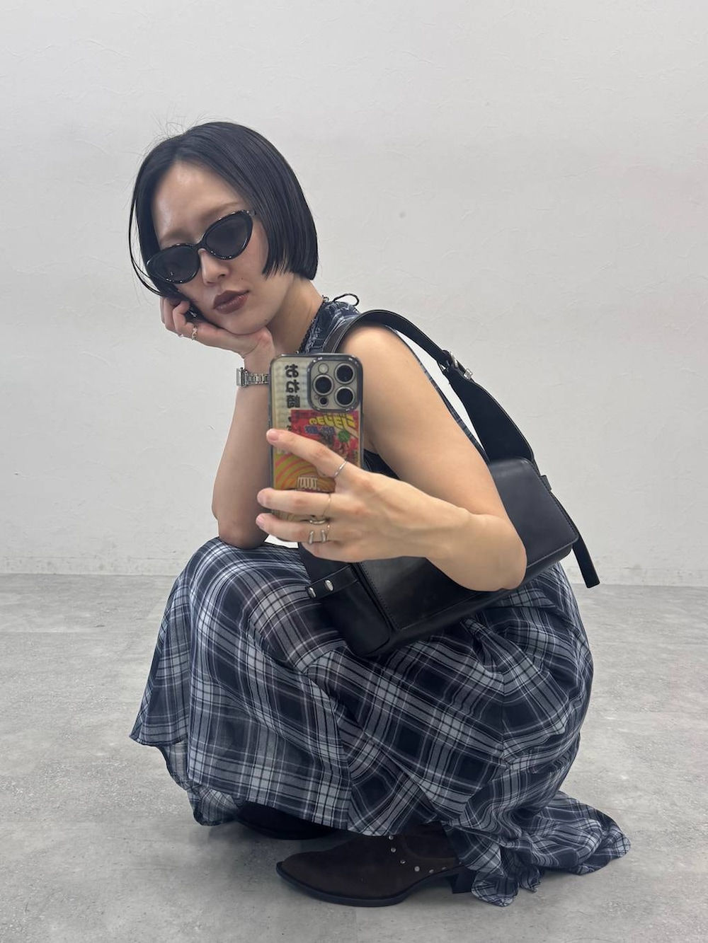 ブラウン系のブーツ、ブラック系のショルダーバッグ、ブルー系のワンピースを着用したレディースの春コーディネートの3枚目の写真