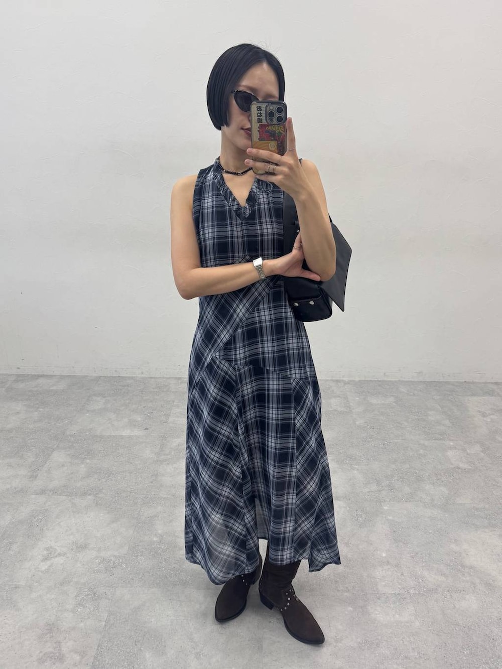 ブラウン系のブーツ、ブラック系のショルダーバッグ、ブルー系のワンピースを着用したレディースの春コーディネートの2枚目の写真