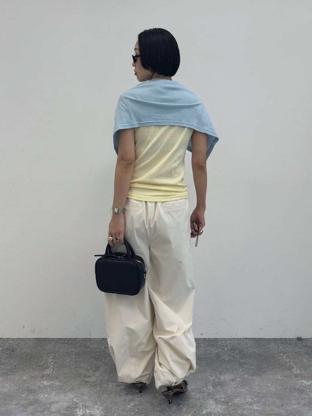 ブラック系のショルダーバッグ、ベージュ系のパンプス、ホワイト系のその他パンツを着用したレディースの冬コーディネートの3枚目の写真