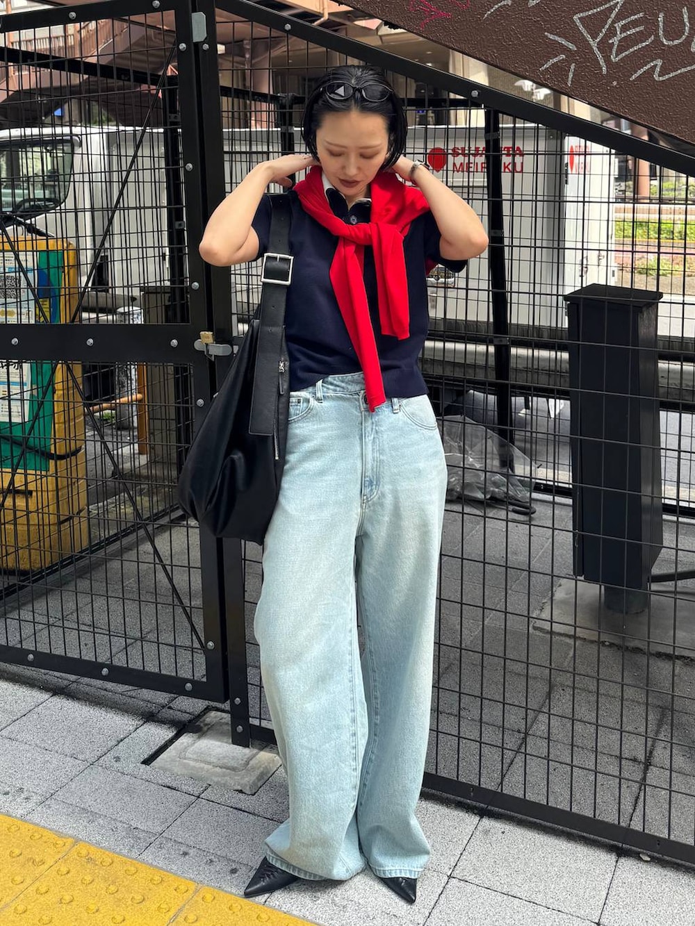 ブラック系のパンプス、ブルー系のデニムパンツを着用したレディースの春コーディネートの5枚目の写真