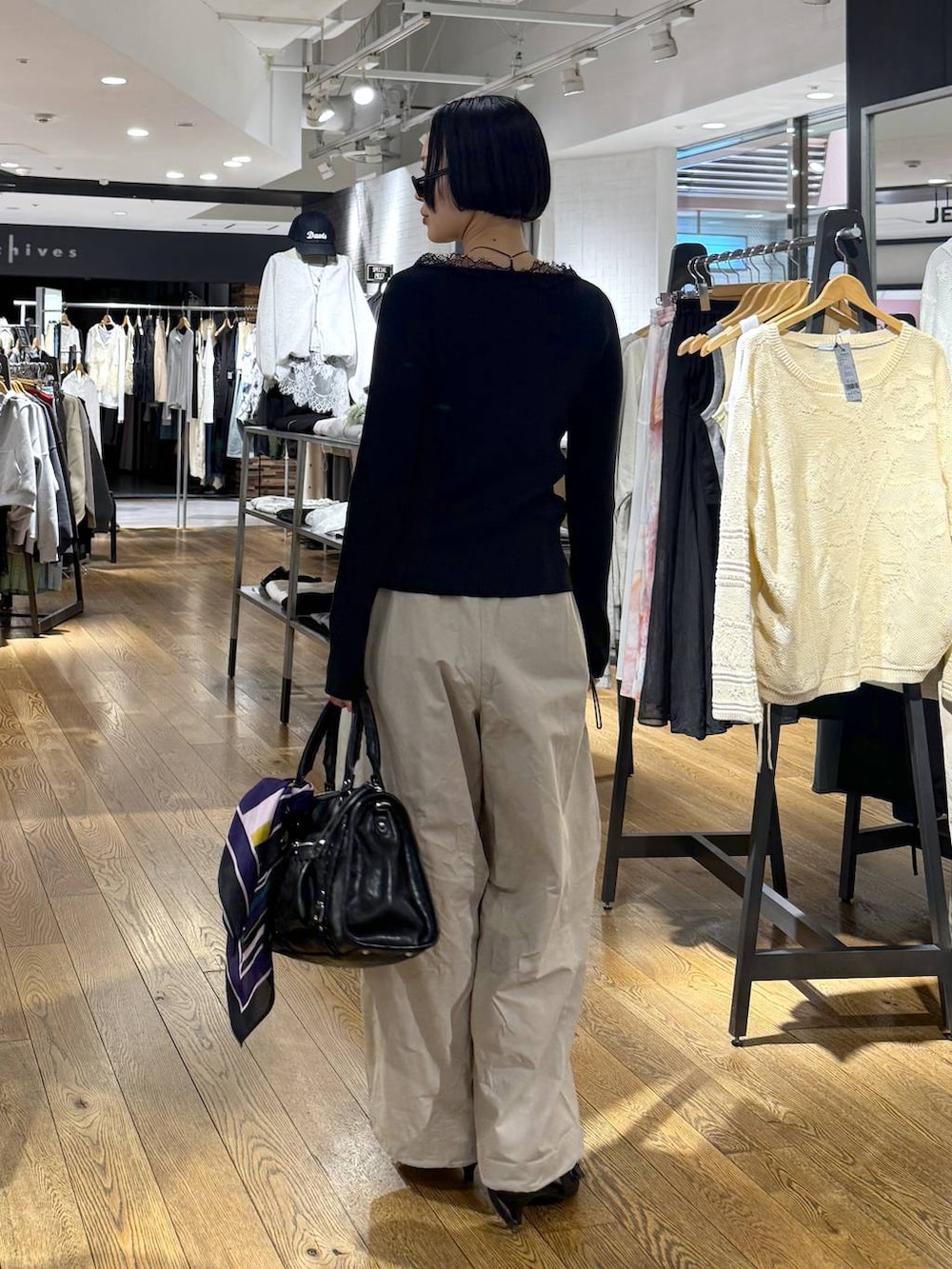 ブラック系のパンプス、ブラック系のボストンバッグ、ベージュ系のその他パンツを着用したレディースの春コーディネートの3枚目の写真