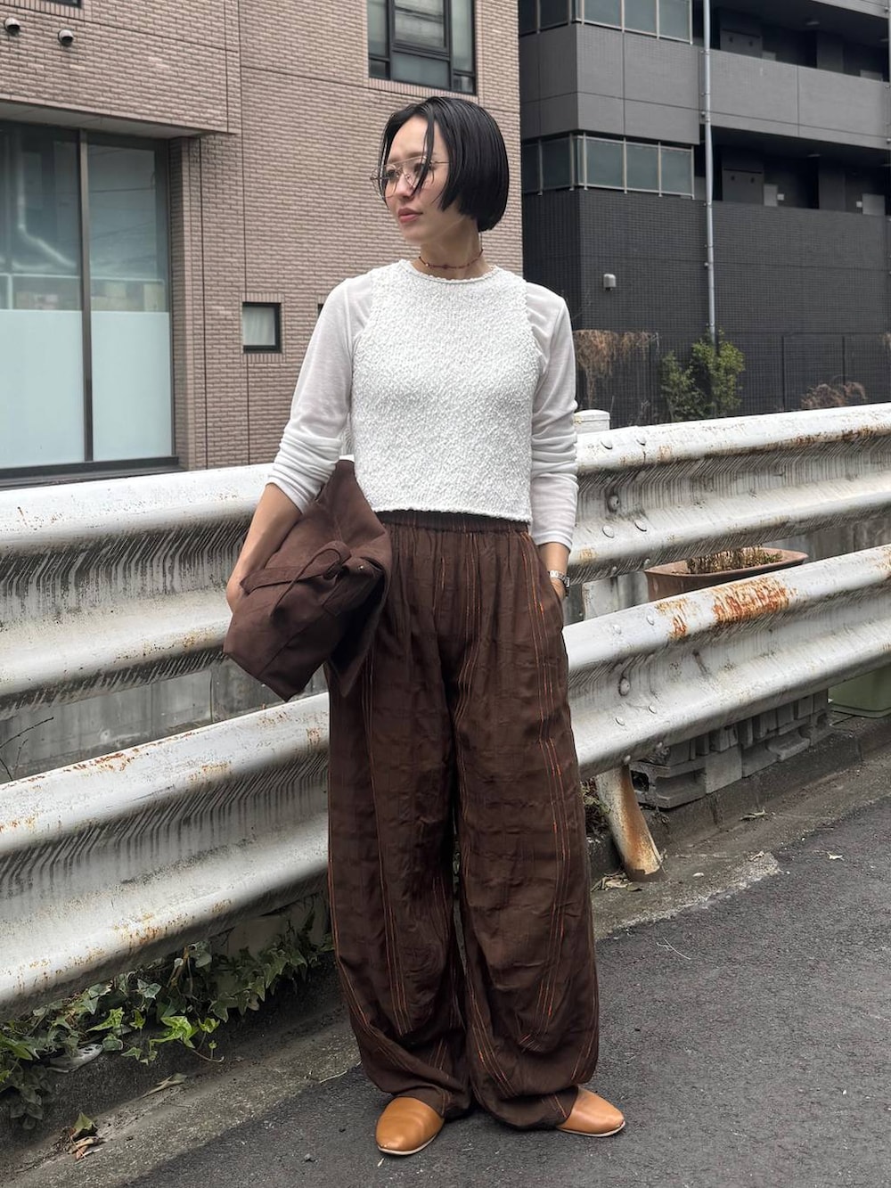 ブラウン系のショルダーバッグを着用したレディースの春コーディネートの3枚目の写真