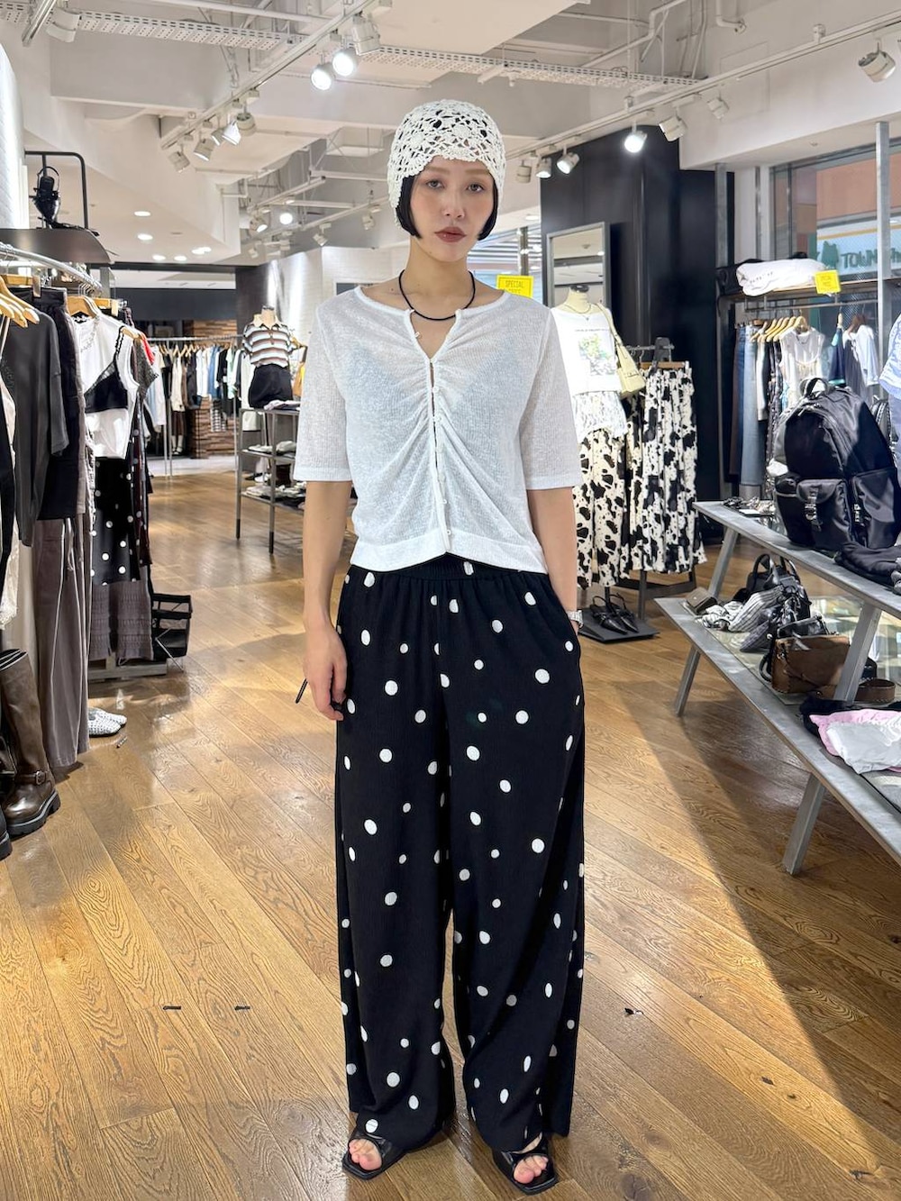 ブラック系のその他パンツ、ホワイト系のカーディガン/ボレロ、ブラック系のパンプスを着用したレディースの夏コーディネートの6枚目の写真