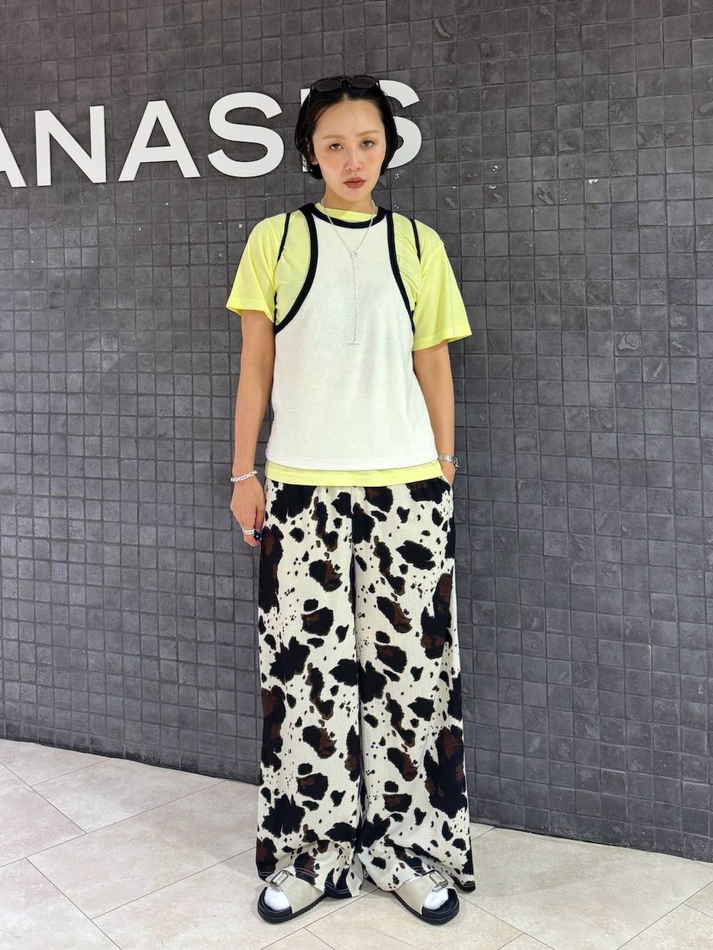 ベージュ系のその他パンツ、ホワイト系のサンダル、イエロー系のTシャツ/カットソーを着用したレディースの夏コーディネートの4枚目の写真