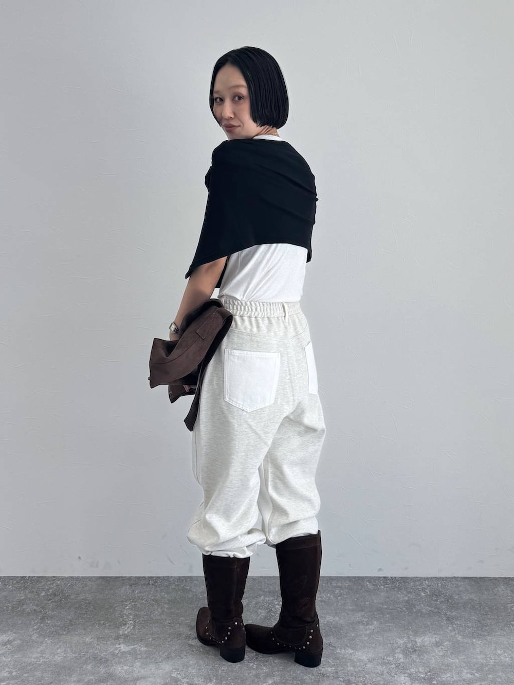 ブラック系のブーツ、ブラウン系のショルダーバッグを着用したレディースの冬コーディネートの5枚目の写真