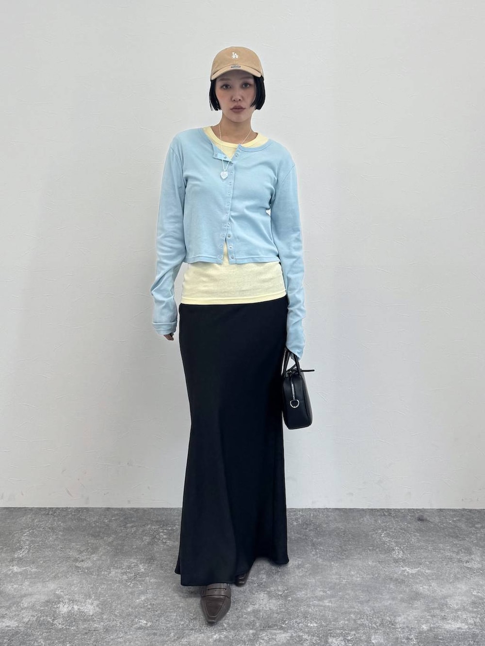 ブラウン系のローファー、ブラック系のショルダーバッグ、ブラック系のスカートを着用したレディースの冬コーディネートの6枚目の写真