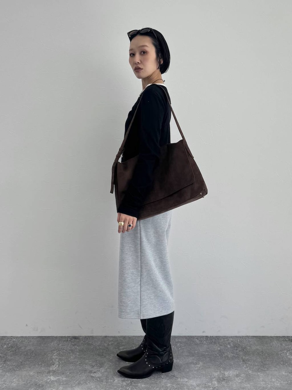 ブラック系のブーツ、ブラウン系のショルダーバッグを着用したレディースの冬コーディネートの4枚目の写真