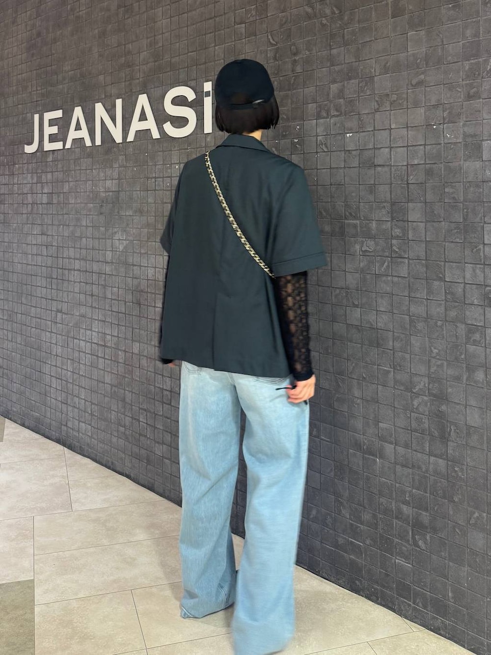 ブラック系のTシャツ/カットソー、ブルー系のデニムパンツ、グレー系のテーラードジャケットを着用したレディースの春コーディネートの4枚目の写真