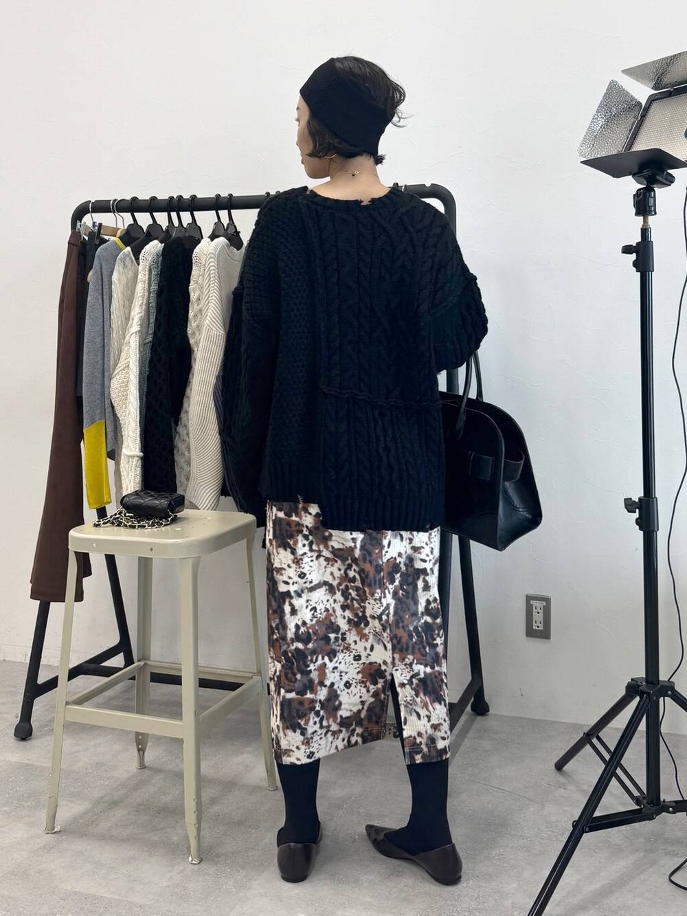 ベージュ系のスカート、ブラック系のショルダーバッグ、ブラック系のニット/セーターを着用したレディースの秋コーディネートの5枚目の写真