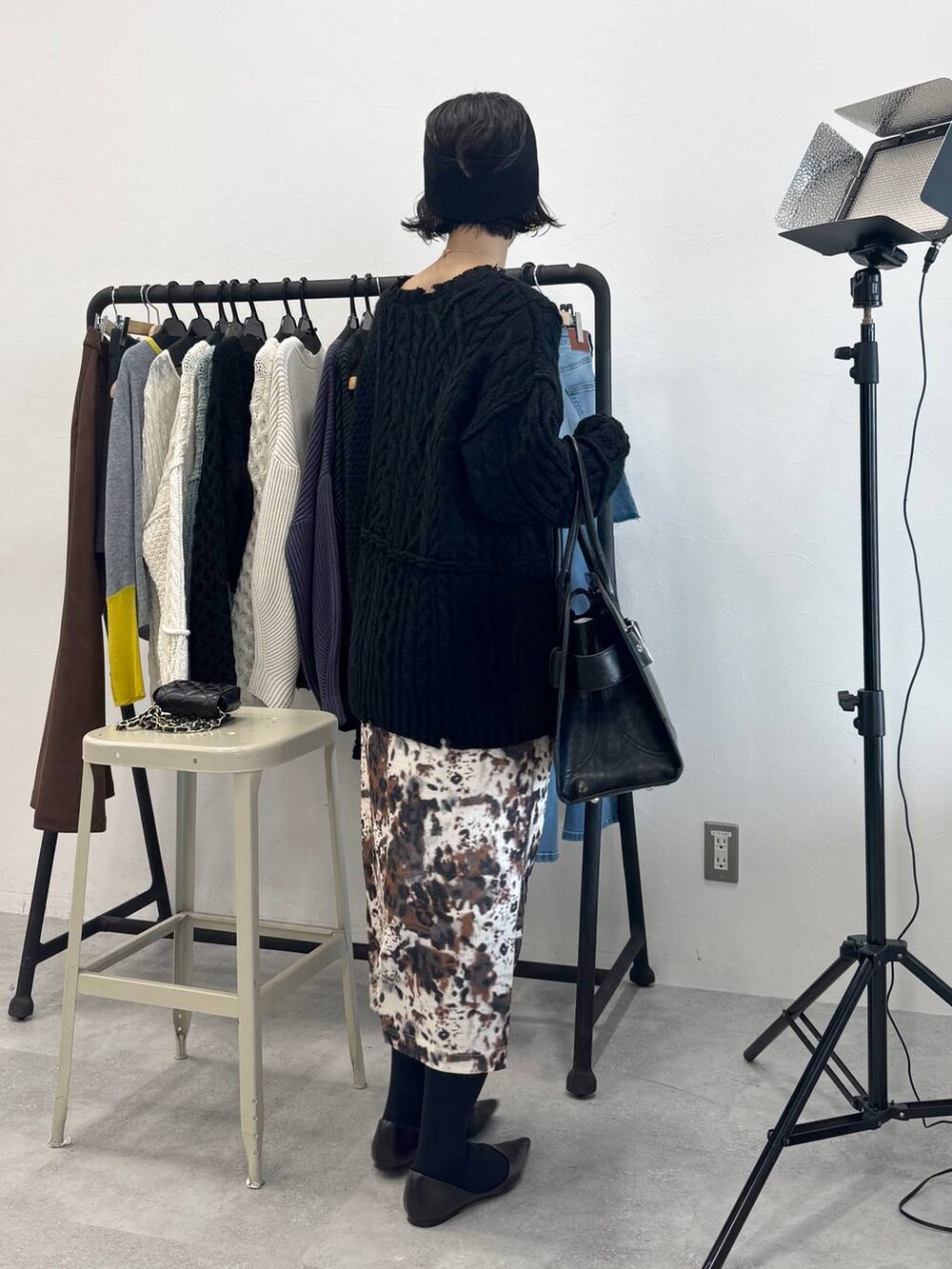 ベージュ系のスカート、ブラック系のショルダーバッグ、ブラック系のニット/セーターを着用したレディースの秋コーディネートの6枚目の写真