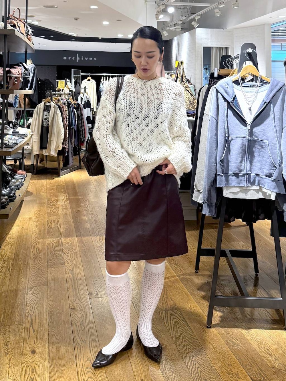 ブラウン系のショルダーバッグ、ホワイト系のニット/セーター、ブラウン系のスカートを着用したレディースの秋コーディネートの3枚目の写真