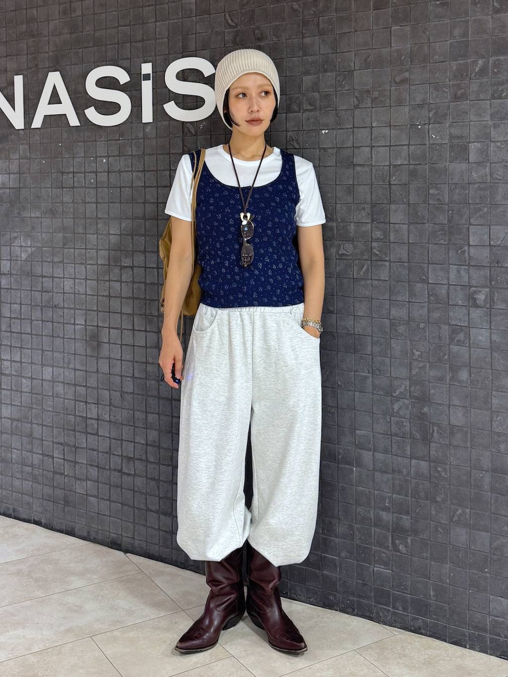 ブルー系のタンクトップ、ホワイト系のTシャツ/カットソー、ベージュ系のスウェットパンツを着用したレディースの夏コーディネートの5枚目の写真