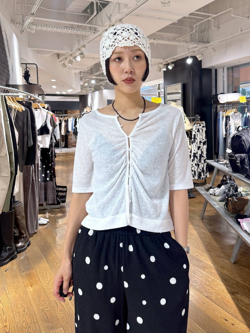 ブラック系のその他パンツ、ホワイト系のカーディガン/ボレロ、ブラック系のパンプスを着用したレディースの夏コーディネートの8枚目の写真