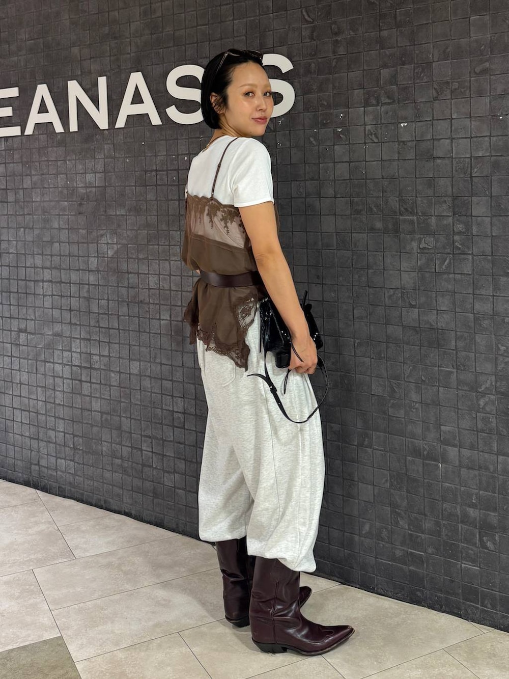 ホワイト系のTシャツ/カットソー、ベージュ系のスウェットパンツ、ブラック系のショルダーバッグを着用したレディースの夏コーディネートの3枚目の写真