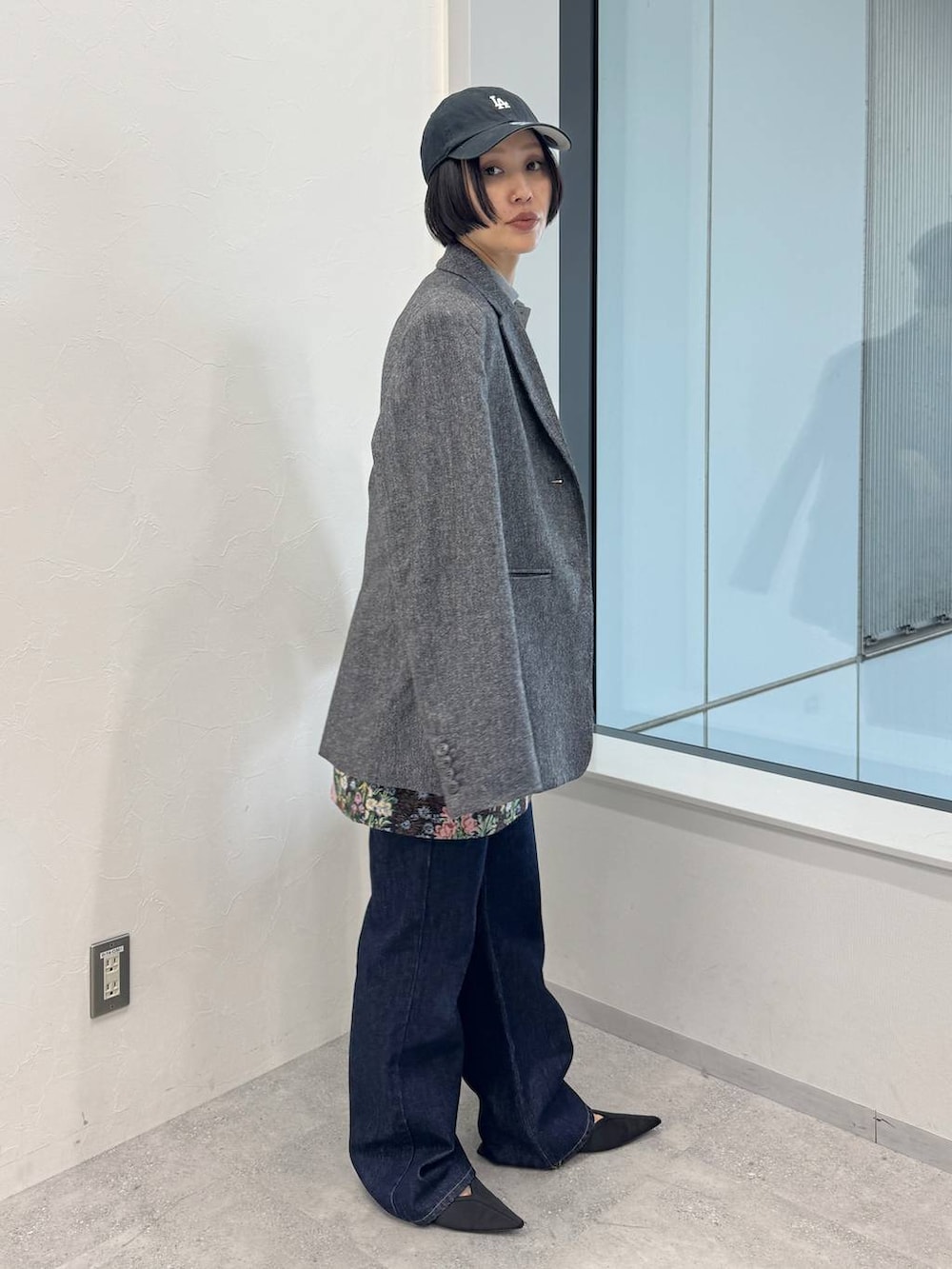 ブルー系のデニムパンツ、ブラック系のスカート、ブラック系のサンダルを着用したレディースの夏コーディネートの2枚目の写真