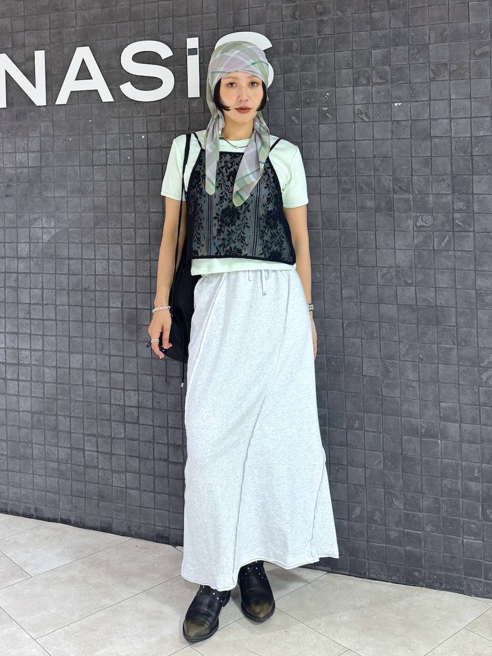グレー系のスカート、ブラック系のブーツ、グリーン系のTシャツ/カットソーを着用したレディースの夏コーディネートの4枚目の写真