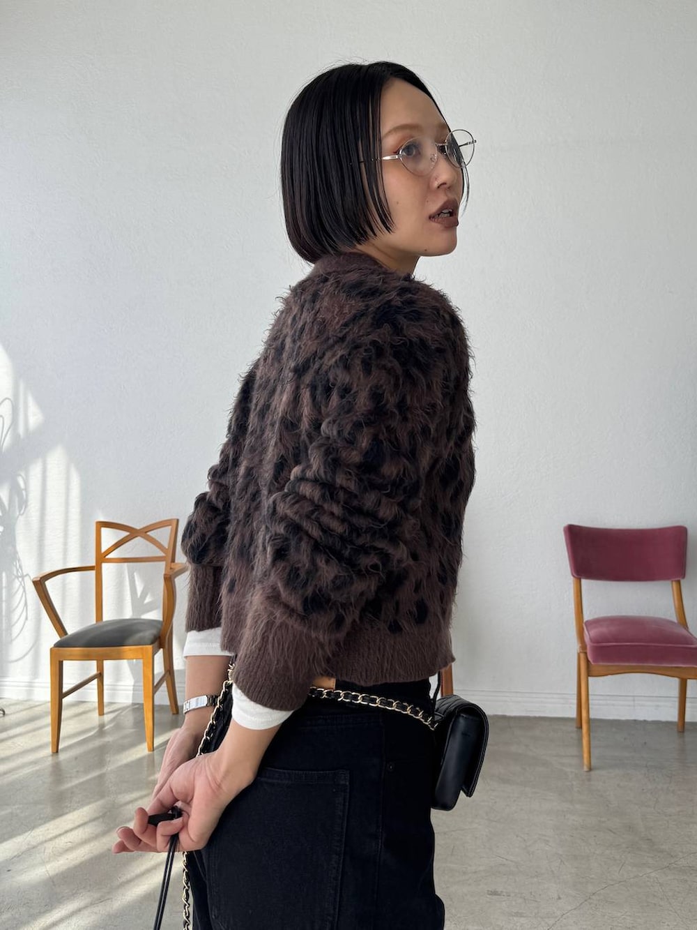 ブラック系のデニムパンツ、ホワイト系のポロシャツ、ブラウン系のカーディガン/ボレロを着用したレディースの秋コーディネートの6枚目の写真