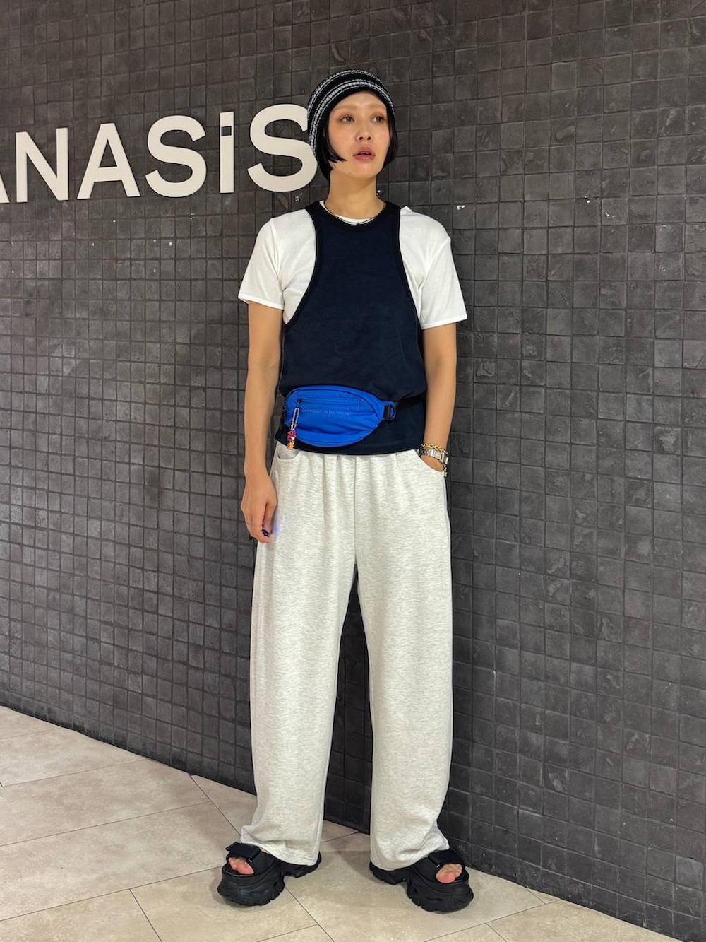 ブラック系のサンダル、ホワイト系のTシャツ/カットソー、ベージュ系のスウェットパンツを着用したレディースの夏コーディネートの2枚目の写真