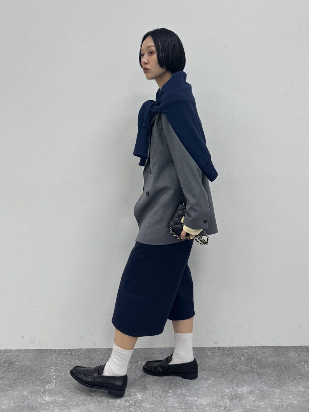 グレー系のテーラードジャケット、ブラック系のローファーを着用したレディースの冬コーディネートの2枚目の写真