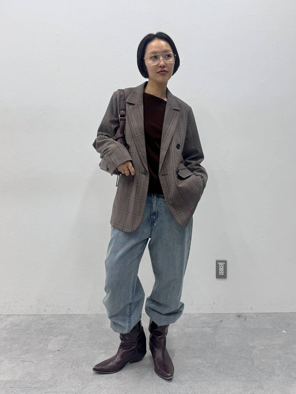 ブルー系のデニムパンツ、ブラウン系のTシャツ/カットソー、レッド系のショルダーバッグを着用したレディースの夏コーディネートの2枚目の写真