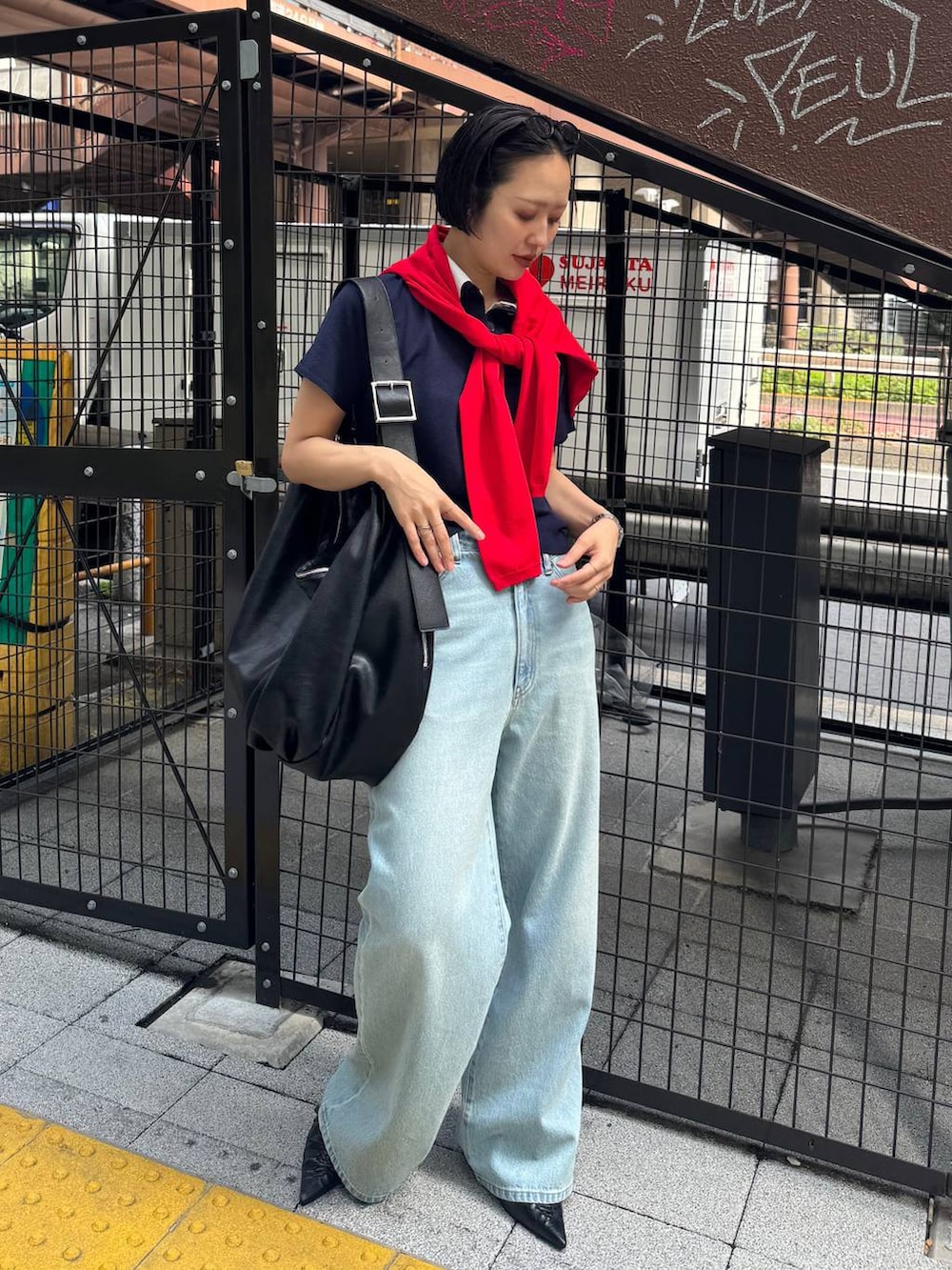 ブラック系のパンプス、ブルー系のデニムパンツを着用したレディースの春コーディネートの3枚目の写真