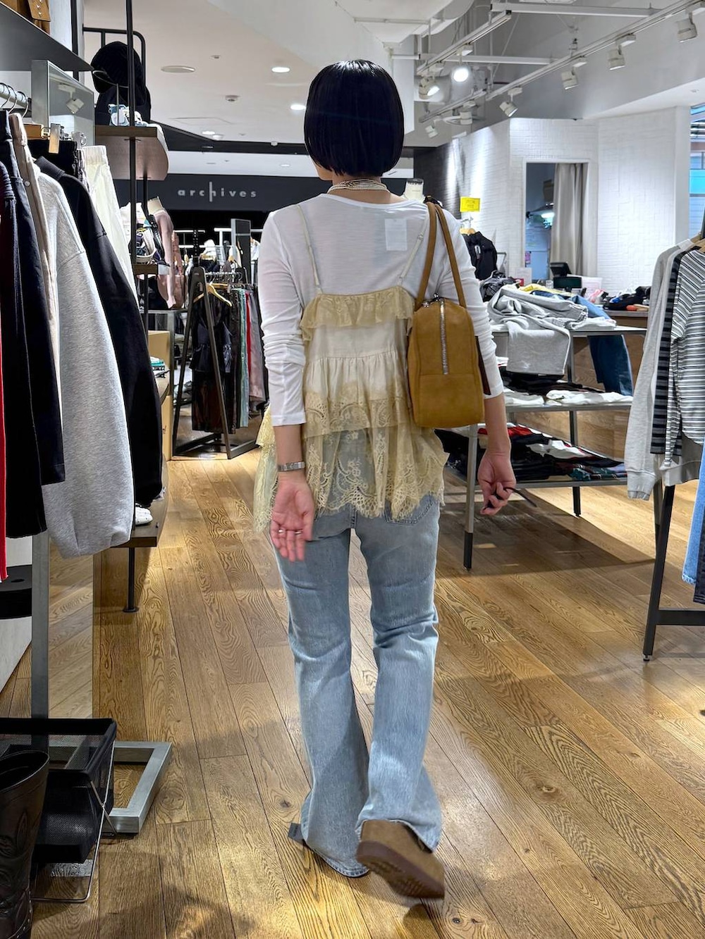 ホワイト系のTシャツ/カットソー、ブラウン系のボストンバッグ、ベージュ系のモカシン/デッキシューズを着用したレディースの春コーディネートの5枚目の写真