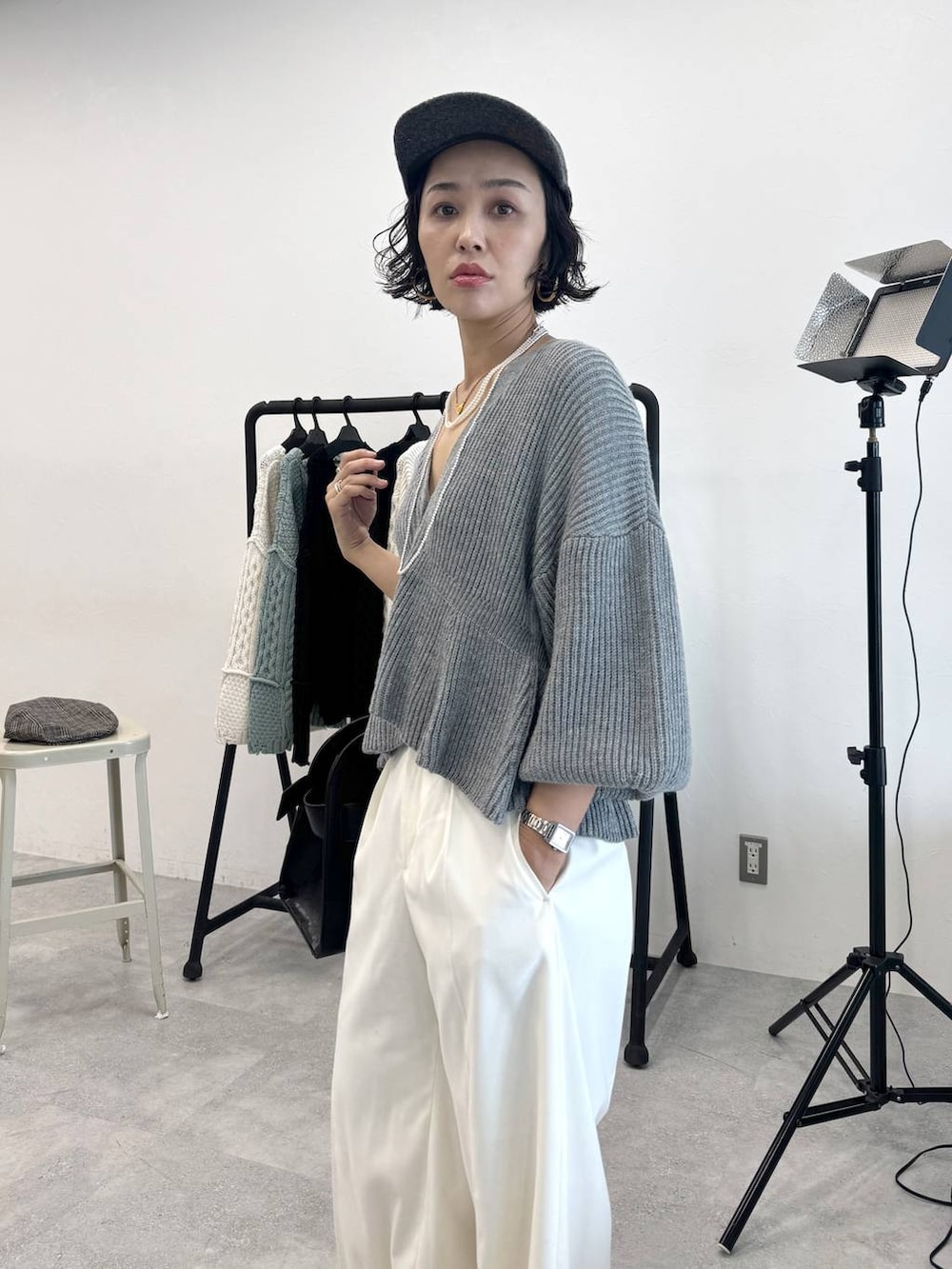 ホワイト系のスラックス、ブラック系のショルダーバッグ、グレー系のカーディガン/ボレロを着用したレディースの秋コーディネートの6枚目の写真