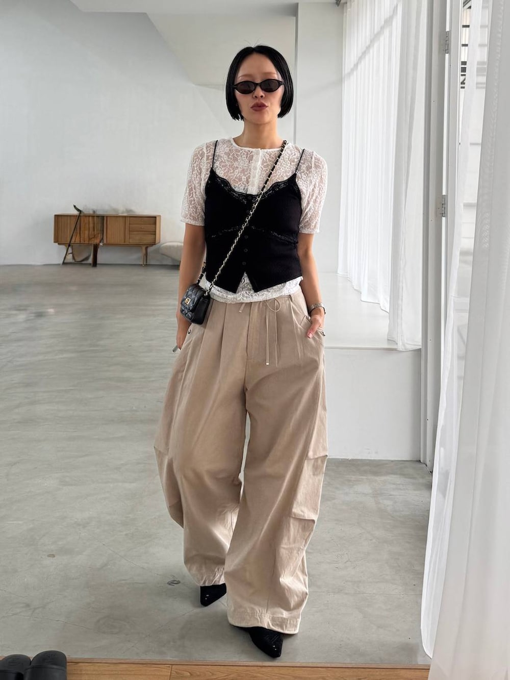ブラック系のパンプス、ベージュ系のその他パンツ、ホワイト系のTシャツ/カットソーを着用したレディースの春コーディネートの3枚目の写真