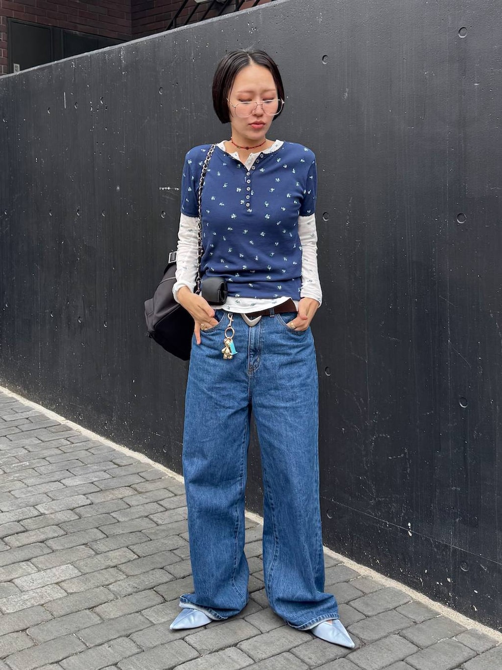 ブラック系のバックパック/リュック、ブルー系のTシャツ/カットソー、ブラウン系のベルトを着用したレディースの春コーディネートの6枚目の写真