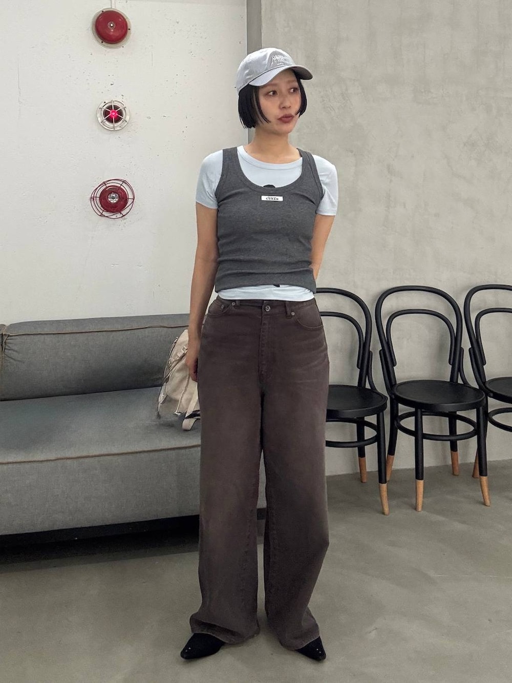 ブラック系のパンプス、ブラウン系のデニムパンツを着用したレディースの春コーディネートの2枚目の写真
