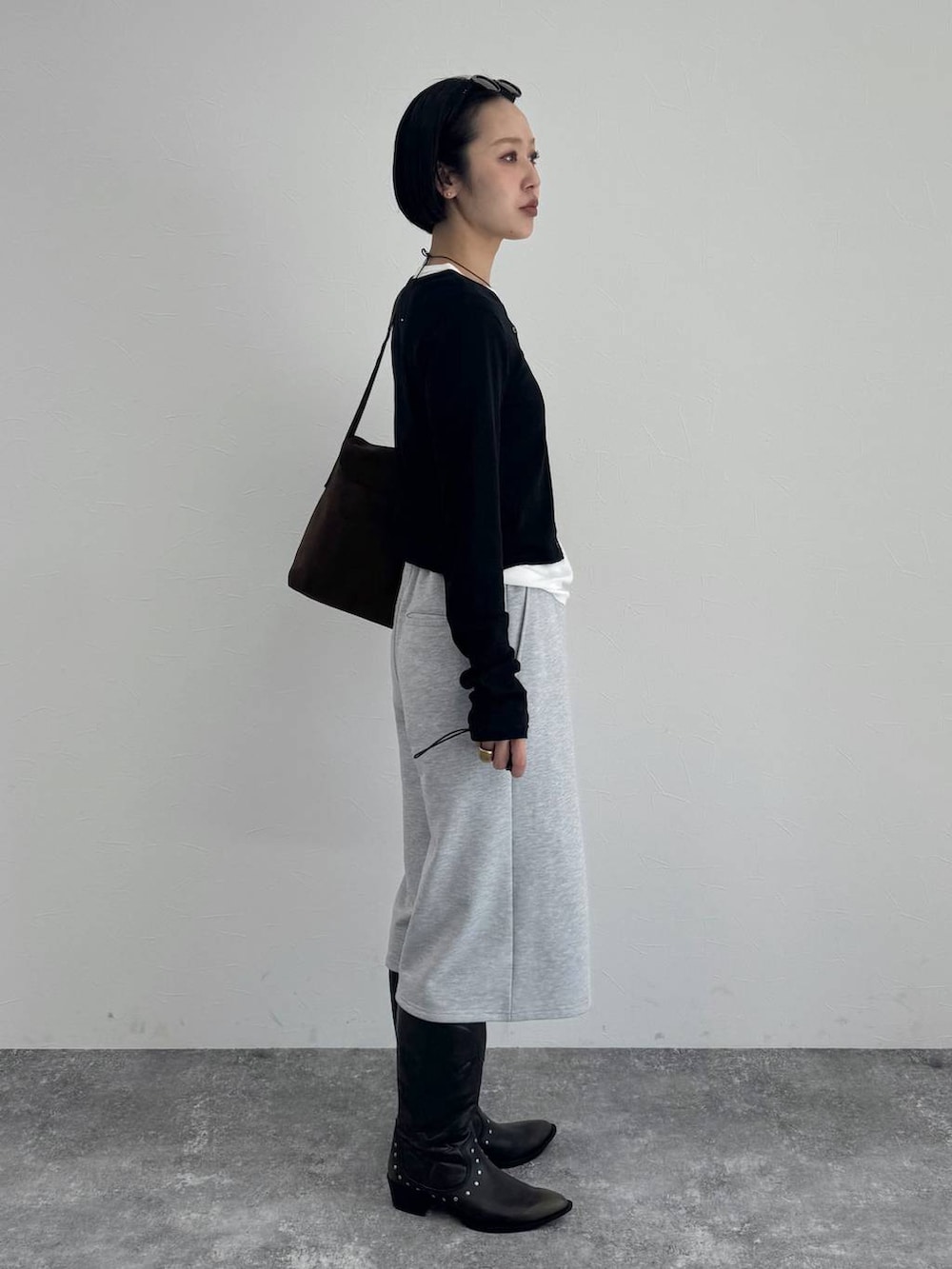 ブラック系のブーツ、ブラウン系のショルダーバッグを着用したレディースの冬コーディネートの2枚目の写真