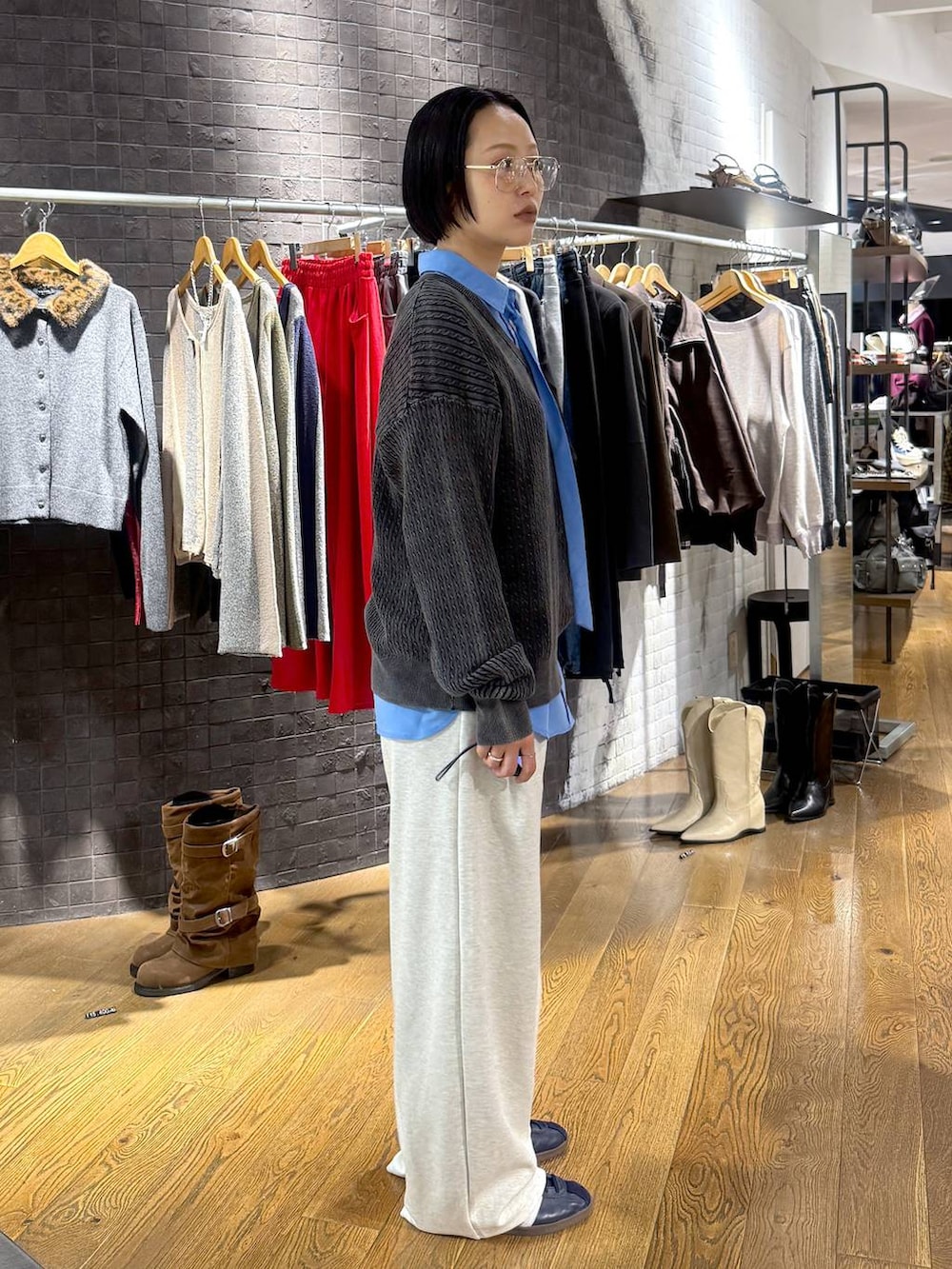 ブルー系のシャツ/ブラウス、ブラック系のニット/セーター、ベージュ系のスウェットパンツを着用したレディースの秋コーディネートの2枚目の写真