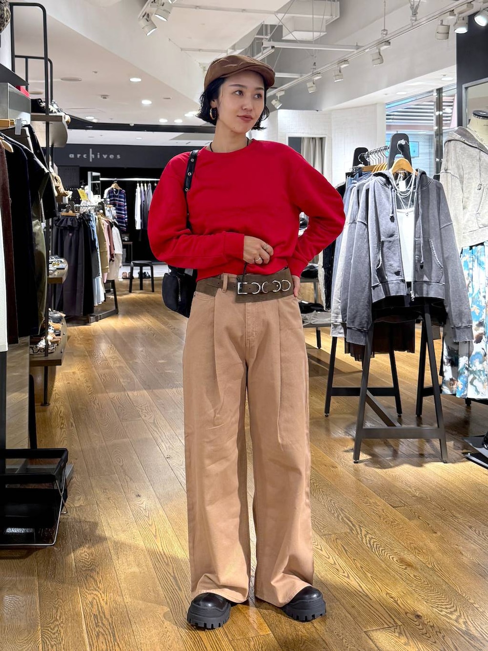 ベージュ系のデニムパンツ、ブラック系のショルダーバッグ、ブラック系のブーツを着用したレディースの秋コーディネートの2枚目の写真