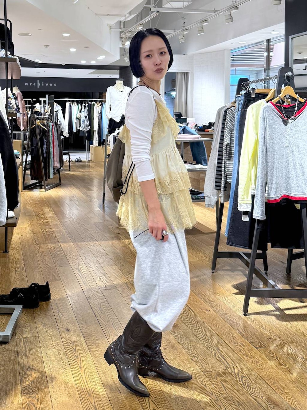 ホワイト系のTシャツ/カットソー、ブラック系のブーツ、グレー系のスウェットパンツを着用したレディースの春コーディネートの4枚目の写真