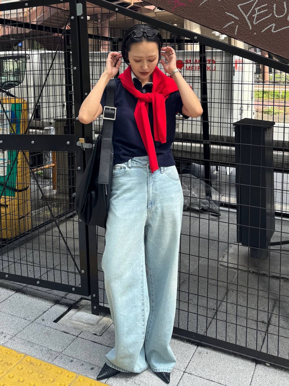 ブラック系のパンプス、ブルー系のデニムパンツを着用したレディースの春コーディネートの2枚目の写真