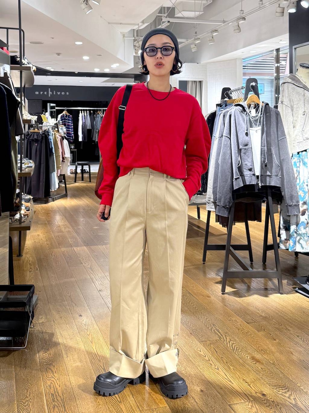 ブラウン系のショルダーバッグ、ブラック系のブーツ、ベージュ系のチノパンツを着用したレディースの秋コーディネートの3枚目の写真